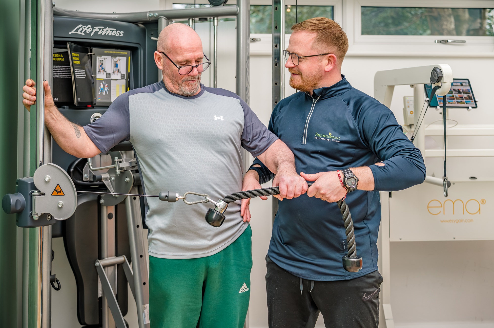 Exercise Rehab Therapist and Stroke client working in gym